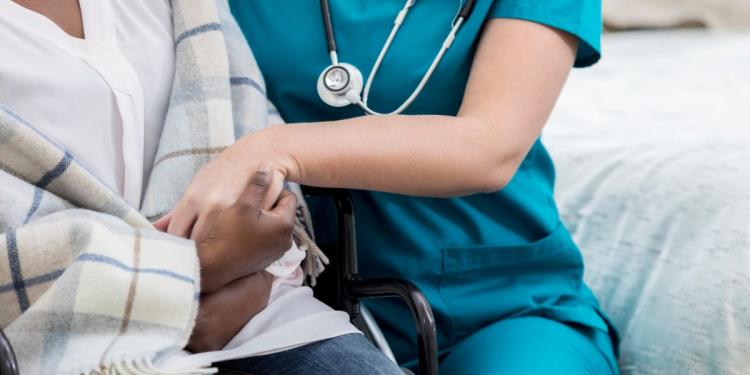 A care provider holds a patients hand