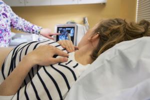 A patient looks at a screen during a sonogram