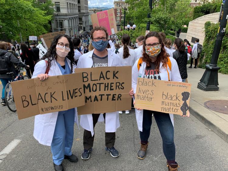 Health care providers holding up black lives matter signs