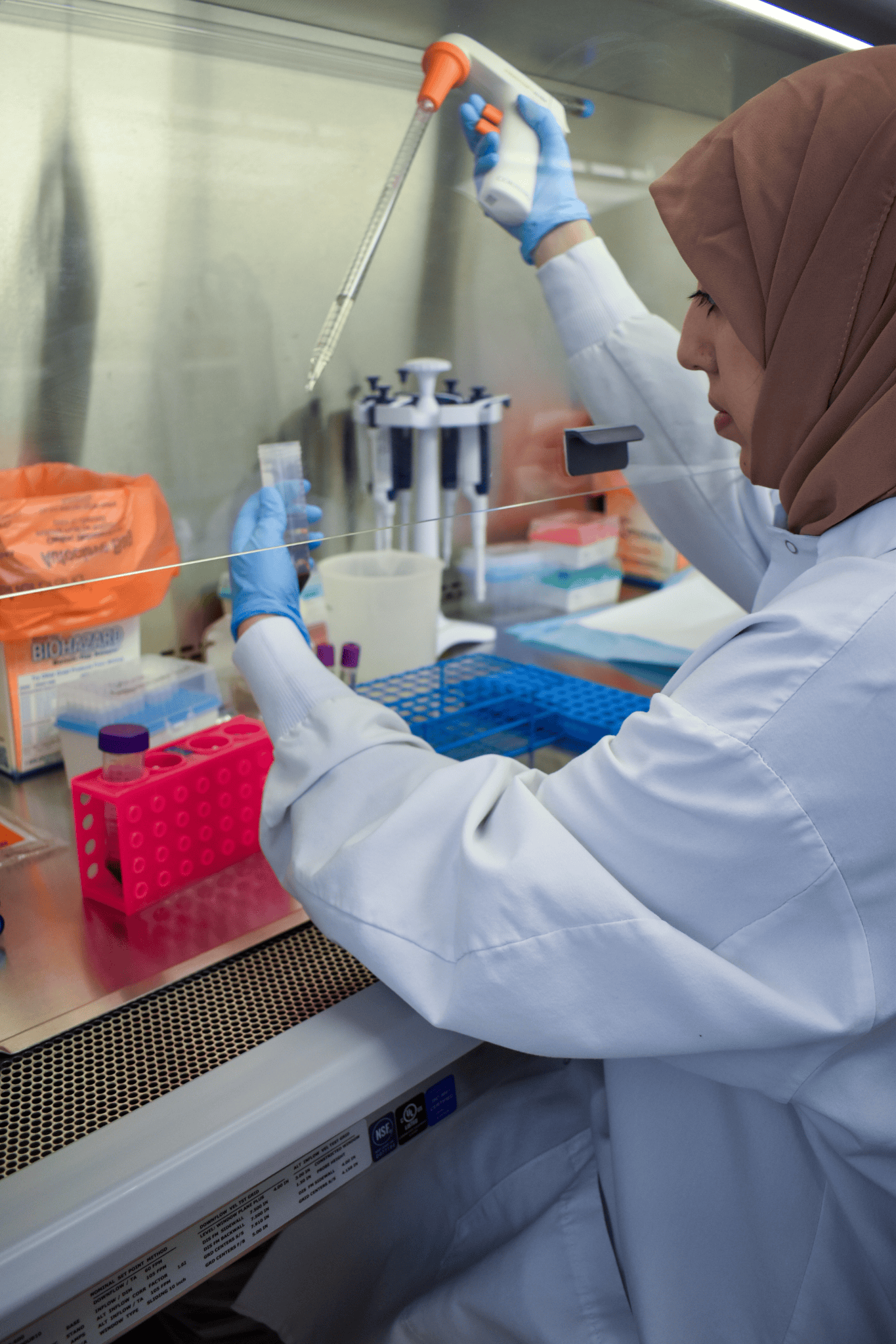 research staff member pipetting in a fume hood