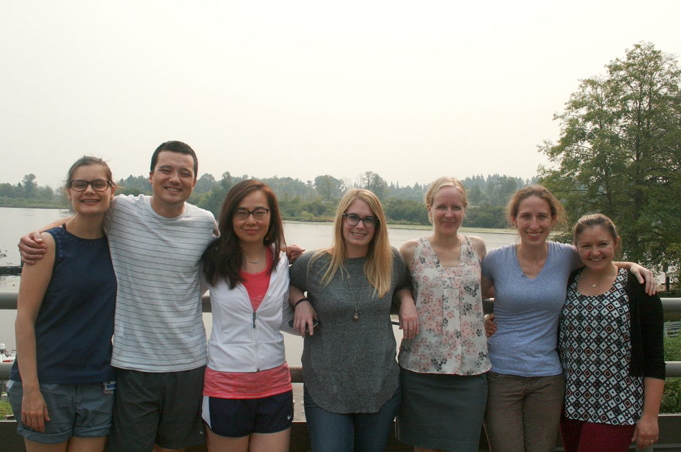 The class of 2020 gathers and smiles in front of a lake
