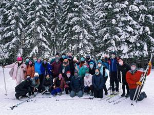 A group of people gather with ski gear in the snow